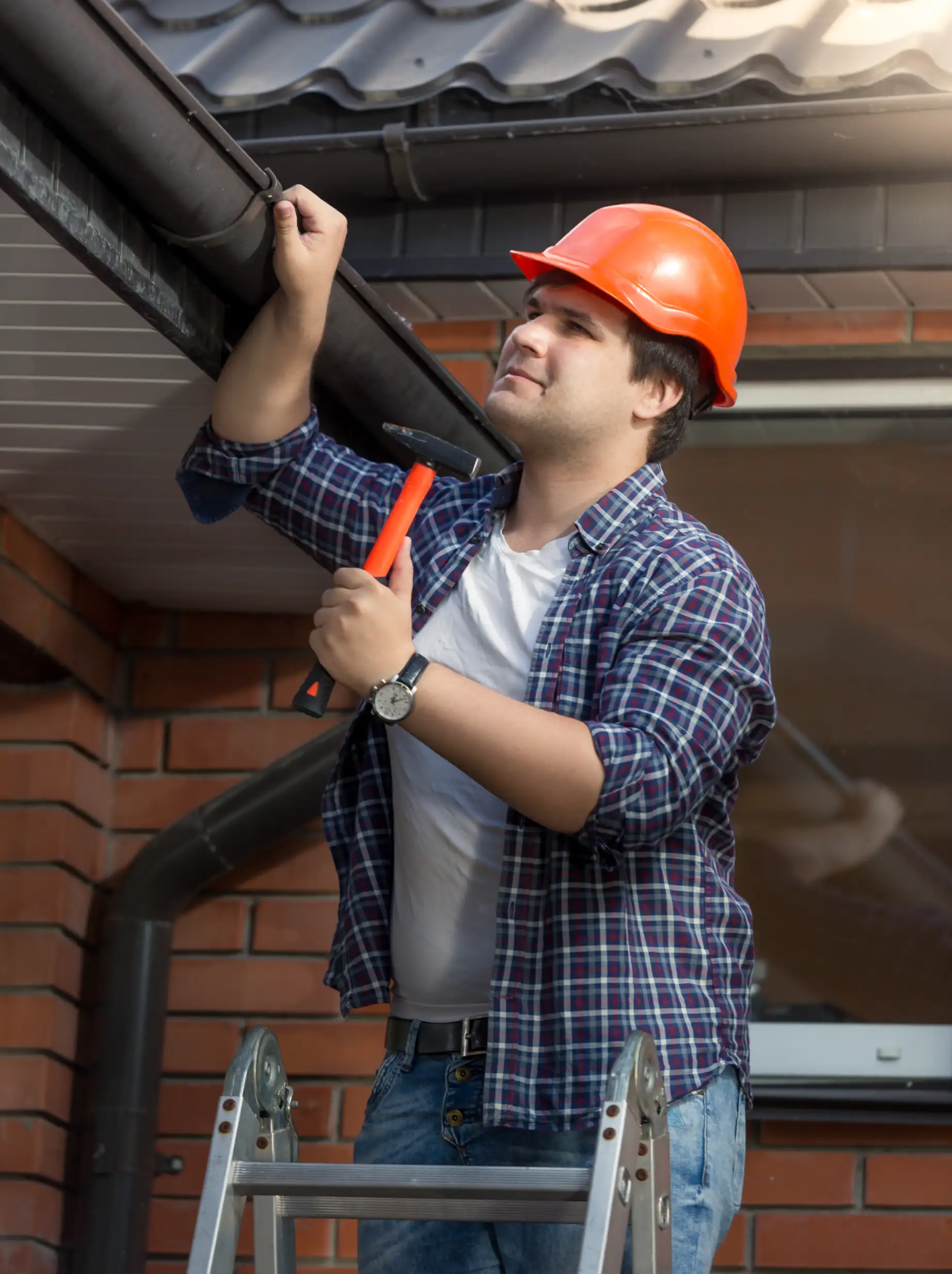 Technician examining a residential gutter to assess needed gutter repair.